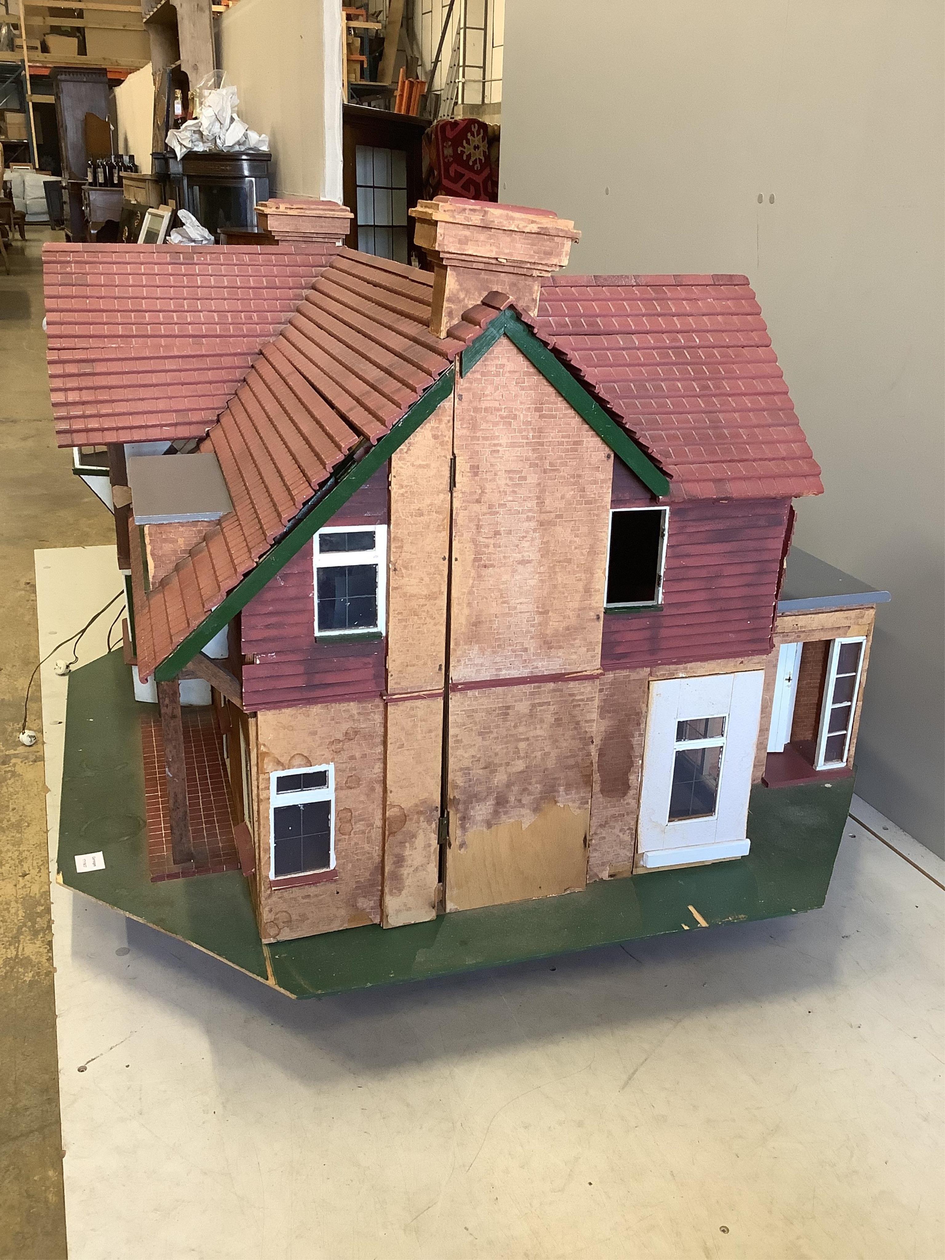 A mid 20th century scratch built mock Tudor doll’s house with some accessories, width 120cm, height 76cm. Condition fair.